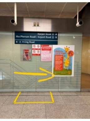 Concourse inside Tai Seng MRT station: a yellow arrow points right, past the MacPherson Road and Airport Road wayfinding sign, towards Exit B.